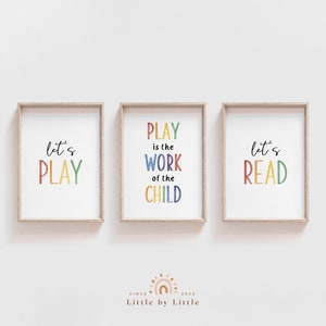 Peut inclure: Trois impressions encadrées avec du texte coloré. La première impression dit "Let's Play" en couleurs arc-en-ciel. La deuxième impression dit "Play is the work of the child" en couleurs arc-en-ciel. La troisième impression dit "Let's Read" en couleurs arc-en-ciel.