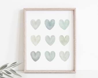 May include: A framed print with nine watercolor hearts in shades of green and blue. The hearts are arranged in a 3x3 grid.