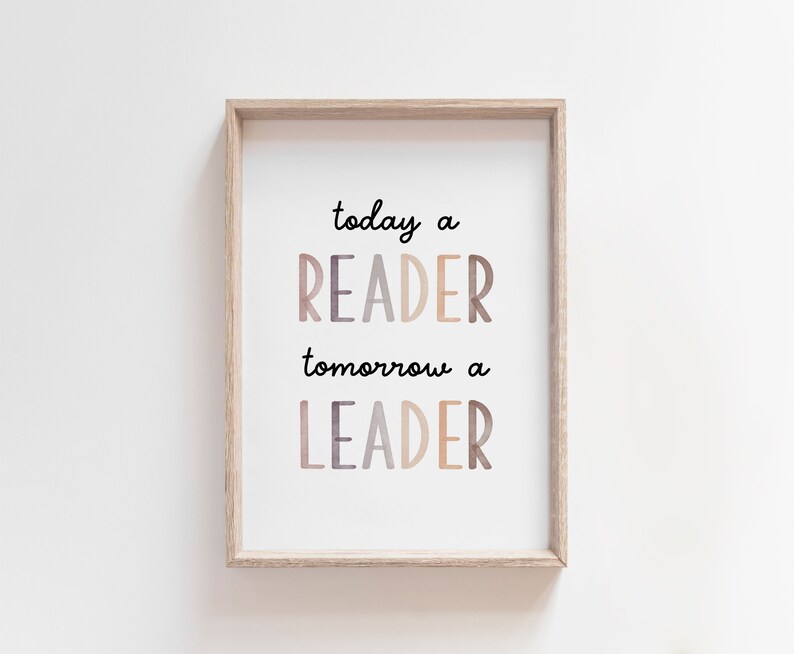 K&ouml;nnte beinhalten: Ein gerahmter Druck mit dem Text "today a READER tomorrow a LEADER" in einer bunten, geschichteten Schriftart. Der Druck ist in einem hellen Holzrahmen und h&auml;ngt an einer wei&szlig;en Wand.