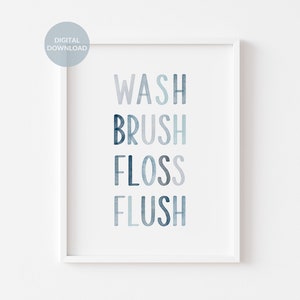 May include: A white framed print with the words "WASH BRUSH FLOSS FLUSH" in a blue watercolor font.