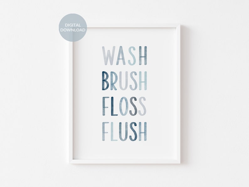 May include: A white framed print with the words "WASH BRUSH FLOSS FLUSH" in a blue watercolor font.