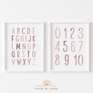 May include: Two framed prints with a white background. The left print features the alphabet in pink and red watercolor letters. The right print features the numbers 0-10 in pink and red watercolor numbers.