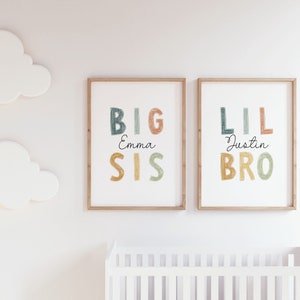 May include: Two framed prints with colorful text. The left print says "BIG SIS Emma" and the right print says "LIL BRO Justin".