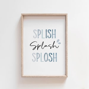 May include: A framed print with the words "Splish Splash Splosh" in a blue watercolor gradient. The words are in a playful font and are perfect for a bathroom or nursery.