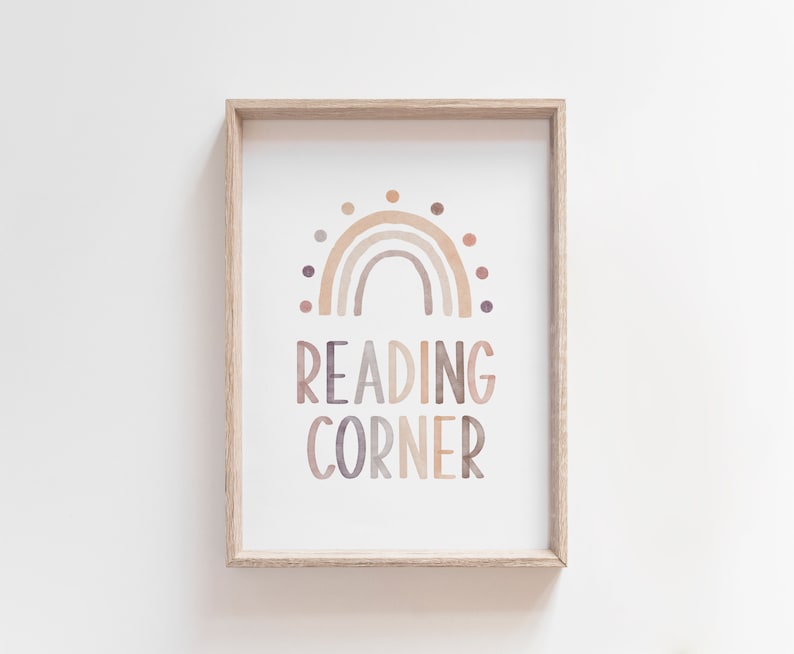 K&ouml;nnte beinhalten: Ein gerahmter Druck mit einem Aquarell-Regenbogen-Design und dem Text "READING CORNER" in einem Farbschema aus Braun, Beige und Lila.