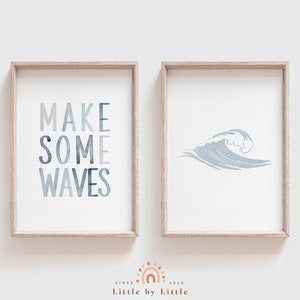 May include: Two framed prints with a coastal theme. The first print features the text "MAKE SOME WAVES" in a blue watercolor style. The second print features a blue watercolor wave.