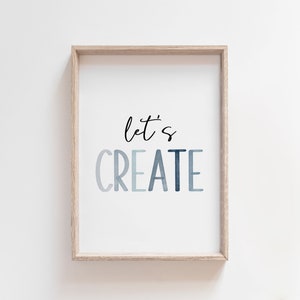May include: A framed print with the text "let's CREATE" in a blue watercolor gradient. The text is in a modern, handwritten font.