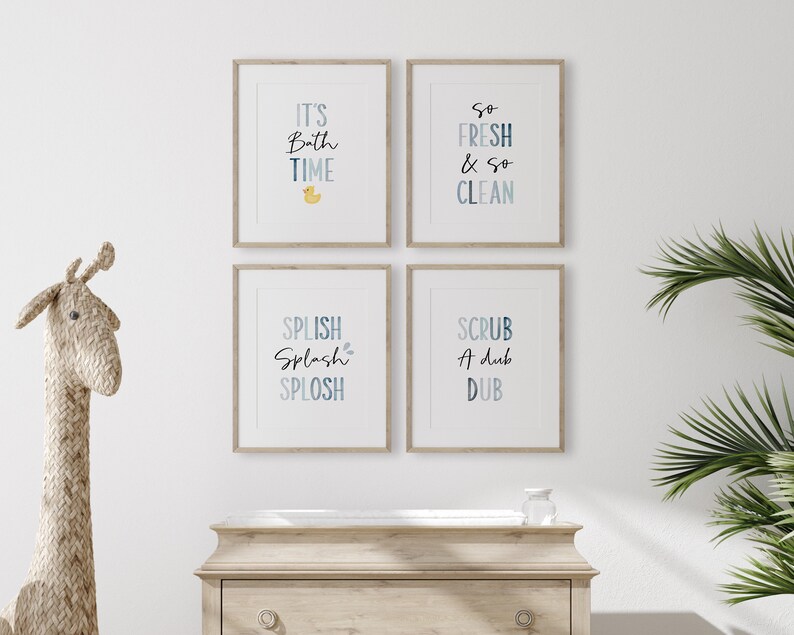 May include: Four framed prints with blue and white watercolor text on a white background. The prints feature bathroom-themed phrases: "It's Bath Time", "So Fresh & So Clean", "Splish Splash Splosh", and "Scrub A Dub Dub".
