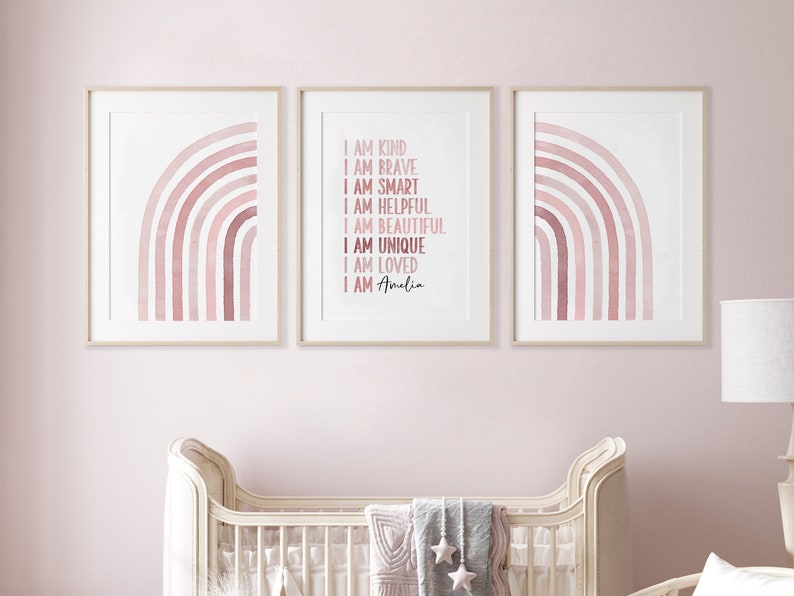 May include: Three framed prints featuring pink watercolour rainbows. The centre print displays the text "I am kind, I am brave, I am smart, I am helpful, I am beautiful, I am unique, I am loved, I am Amelia".