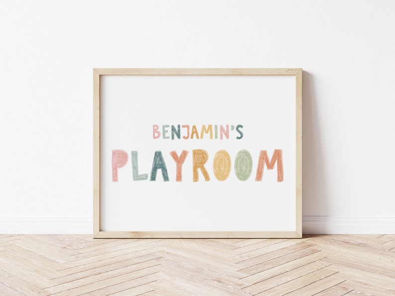 May include: A framed print with the text "Benjamin's Playroom" in colorful, hand-drawn letters. The letters are in shades of pink, orange, yellow, green, and blue.