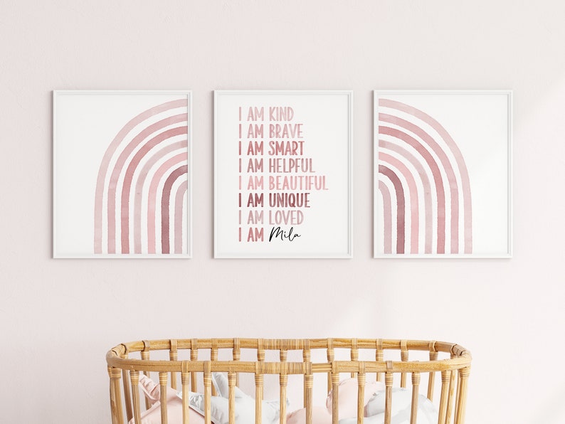 May include: Three framed prints featuring pink watercolour rainbows. The centre print displays the text "I am kind, I am brave, I am smart, I am helpful, I am beautiful, I am unique, I am loved, I am Mila".