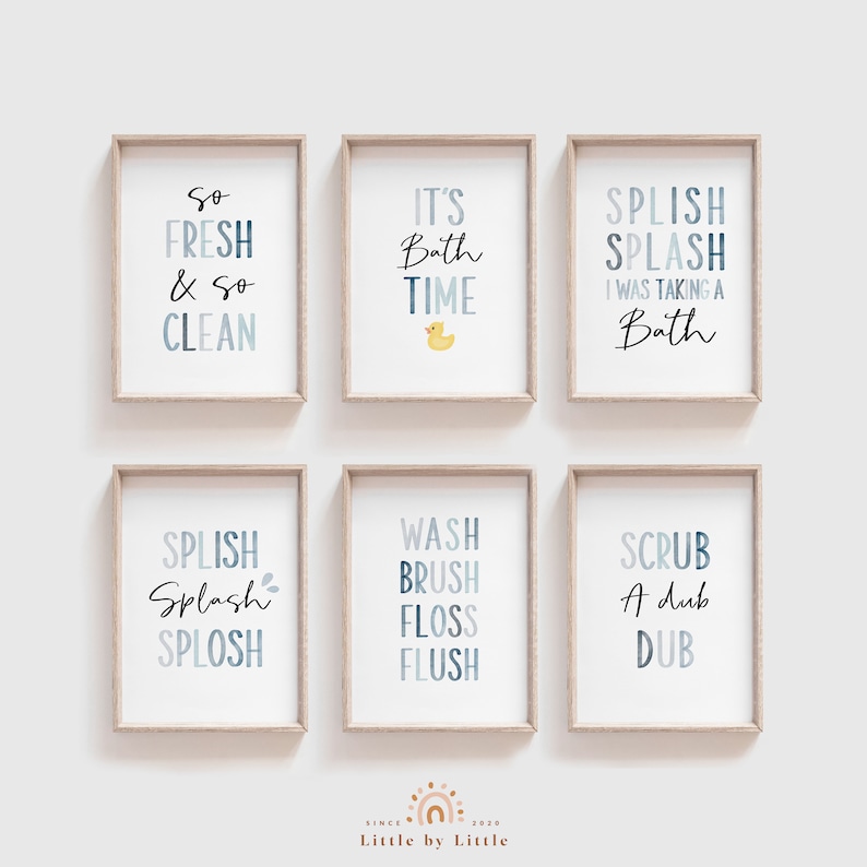 May include: Six framed prints with blue and white text on a white background. The prints feature bathroom-themed phrases like "So Fresh & So Clean", "It's Bath Time", "Splish Splash I Was Taking A Bath", "Splish Splash Splosh", "Wash Brush Floss Flush", and "Scrub A Dub Dub".