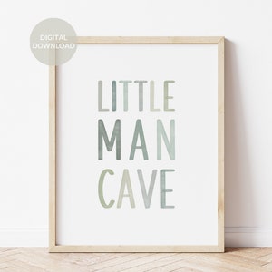 May include: A framed print with the text "LITTLE MAN CAVE" in a watercolor style with shades of green and blue.