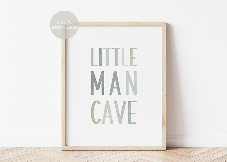 May include: A framed print with the text "LITTLE MAN CAVE" in a watercolor style with shades of green and blue.