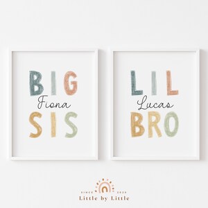 May include: Two white framed prints with colorful text. The left print says "BIG Fiona SIS" and the right print says "LIL Lucas BRO".