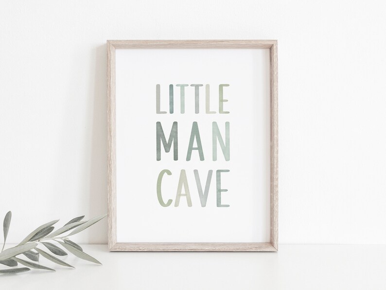 May include: A framed print with the text "LITTLE MAN CAVE" in a light green and gray color scheme.