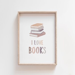K&ouml;nnte beinhalten: Ein gerahmter Druck mit einem Stapel Aquarell-B&uuml;chern und dem Text "ICH LIEBE B&Uuml;CHER" in bunten Buchstaben.