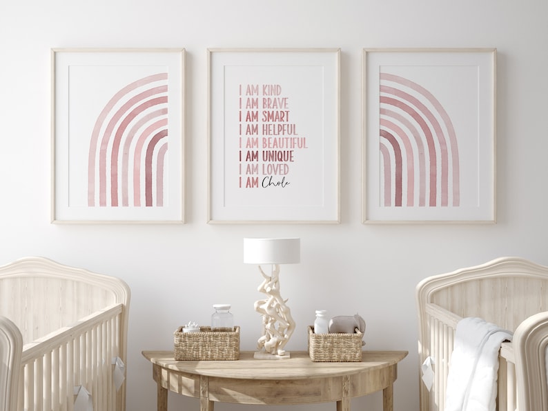 May include: Three framed prints featuring a pink watercolour rainbow design. The centre print includes the text "I am kind, I am brave, I am smart, I am helpful, I am beautiful, I am unique, I am loved, I am Chole".