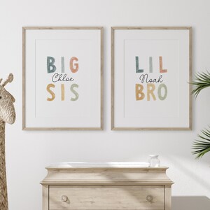May include: Two framed prints with colorful text. The left print says "BIG Chloe SIS" and the right print says "LIL Noah BRO".