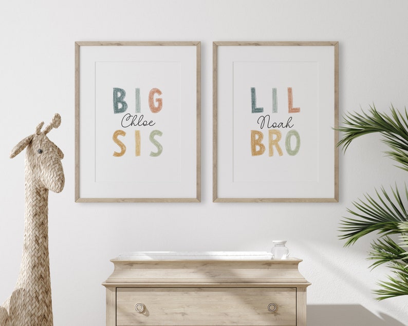 May include: Two framed prints with colorful text. The left print says "BIG Chloe SIS" and the right print says "LIL Noah BRO".