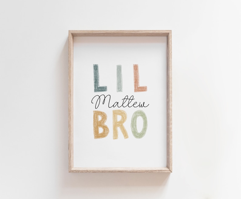 May include: A framed print with the text "Lil Matthew Bro" in colorful, hand-drawn letters. The letters are in shades of blue, green, yellow, and orange.
