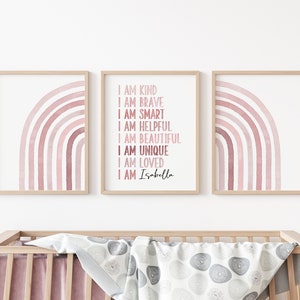 May include: Three framed prints featuring pink watercolour rainbows. The central print displays the text "I am kind, I am brave, I am smart, I am helpful, I am beautiful, I am unique, I am loved, I am Isabella".