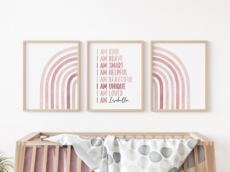 May include: Three framed prints featuring pink watercolour rainbows. The central print displays the text "I am kind, I am brave, I am smart, I am helpful, I am beautiful, I am unique, I am loved, I am Isabella".