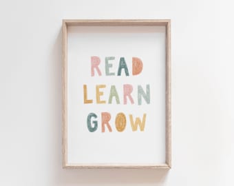Könnte beinhalten: Ein gerahmter Druck mit den Worten "READ LEARN GROW" in bunten, handgezeichneten Buchstaben.