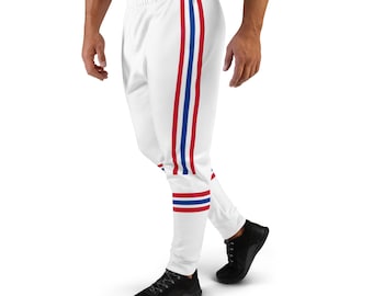 Puede incluir: Pantalones de chándal blancos con rayas rojas y azules a los lados. Las rayas son gruesas y llamativas.