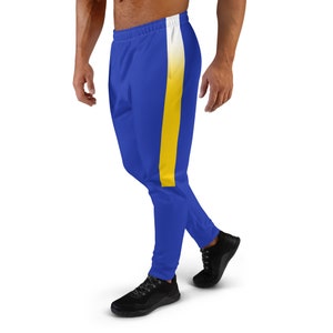 Può includere: Pantaloni della tuta blu con una striscia bianca e gialla sul lato.