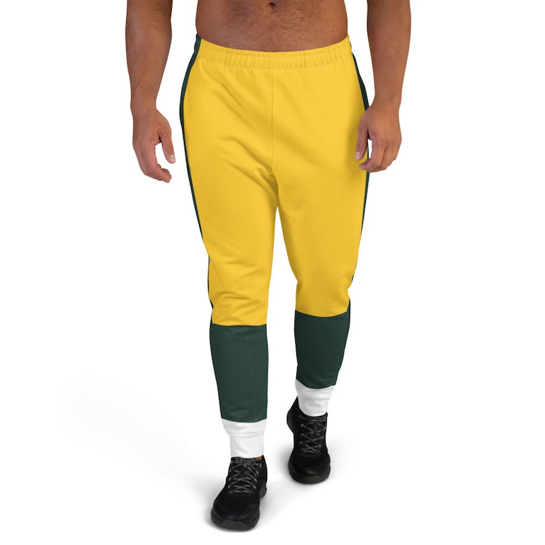 May include: Yellow and green sweatpants with white trim. The sweatpants have a contrasting color block design on the legs.