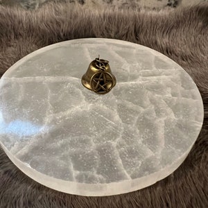 Pu&ograve; includere: Un piatto di ricarica in selenite bianco con una campana in ottone con un ciondolo a pentagramma.