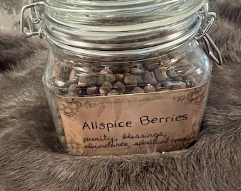Könnte beinhalten: Ein Glasgefäß gefüllt mit Pimentkörnern. Das Gefäß hat ein Etikett mit der Aufschrift "Allspice Berries, purity, blessings, abundance, spiritual connection".