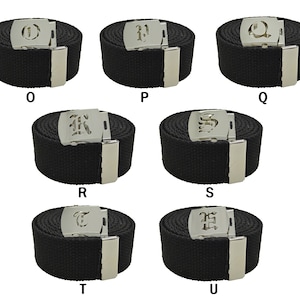 May include: Six black canvas belts with silver buckles featuring different letters of the alphabet in a gothic font. The letters are O, P, Q, R, S, and T.