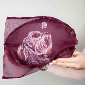 May include: A burgundy sheer fabric bag with a hand-painted portrait of a small dog looking up at a butterfly.