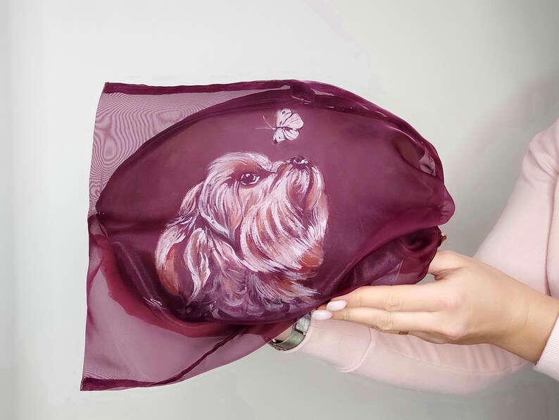 May include: A burgundy sheer fabric bag with a hand-painted portrait of a small dog looking up at a butterfly.