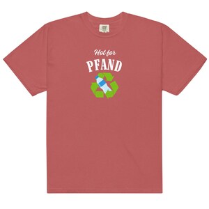 May include: A red-orange t-shirt with the words "Hot for PFAND" above a recycling symbol containing a water bottle. The shirt is made of a soft material and has a classic crew neck.