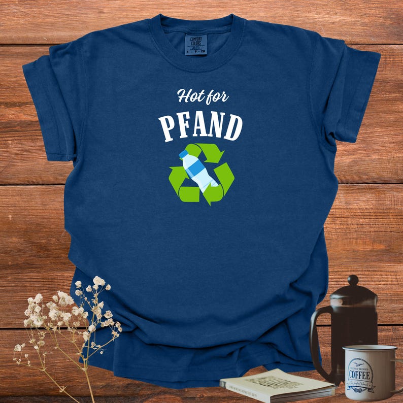 May include: Navy blue t-shirt with the text "Hot for Pfand" above a recycling symbol with a water bottle inside. The shirt is made of a soft material.