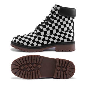 Puede incluir: Una bota con estampado de cuadros blancos y negros con cordones negros y un cuello acolchado negro. La bota tiene una suela marrón y una suela exterior con tacos. La segunda imagen muestra la parte inferior de la bota.