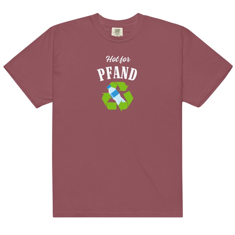 May include: A maroon t-shirt with the words "Hot for PFAND" above a recycling symbol containing a water bottle. The graphic is in white, green, and blue. The shirt is made of a soft material.