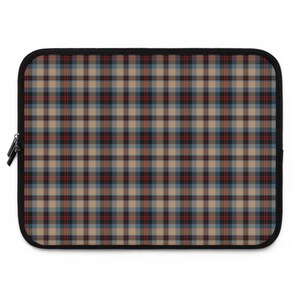 May include: A rectangular laptop sleeve with a black zipper and trim. The sleeve features a plaid pattern in tan, black, red, and blue. The pattern is a repeating grid of intersecting lines.