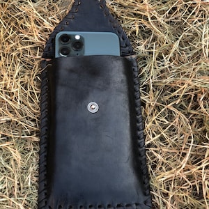 May include: Black leather phone case with a braided design and a snap closure. The case is designed to hold a smartphone with a camera bump.
