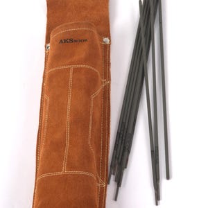 Leather Welding Rod Pouch | Handmade Welder Rod Holder, A brown leather welding rod holder with the text "AKSNOOR" and a set of welding rods. The holder is rectangular with white stitching and a silver clasp. The welding rods are gray and arranged next to the holder.