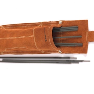 Leather Welding Rod Pouch | Handmade Welder Rod Holder. A brown leather tool pouch with a silver clasp, holding several dark gray welding rods. The pouch has white stitching and the brand name "Hanna Sola" is visible. Several rods are also outside the pouch.
