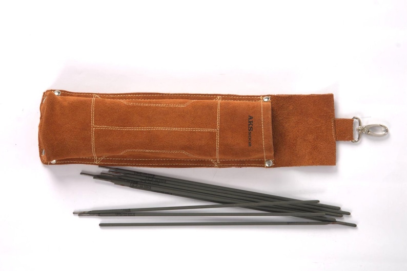 May include: Leather Welding Rod Pouch | Handmade Welder Rod Holder, flap and a metal clasp. The holder is open, revealing several dark gray welding rods. The text "ARS WELDING" is visible on the holder.