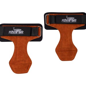 May include: Two weightlifting grips with brown leather palms and black wrist straps. The straps have a silver buckle and the text "AKSNOOR" in white. The grips are designed to protect hands during workouts.