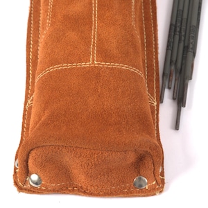 Leather Welding Rod Pouch | Handmade Welder Rod Holder, A close-up of a brown suede leather welding rod holder with white stitching and metal rivets. Several welding rods are visible to the right of the holder. The holder is designed to protect the rods.