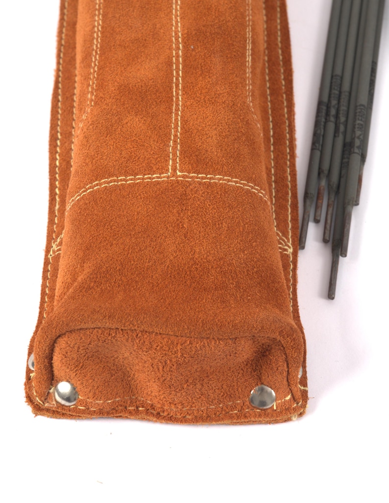Leather Welding Rod Pouch | Handmade Welder Rod Holder, A close-up of a brown suede leather welding rod holder with white stitching and metal rivets. Several welding rods are visible to the right of the holder. The holder is designed to protect the rods.