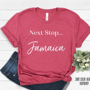 May include: Heather raspberry red t-shirt with the text "Next Stop... Jamaica" in white cursive font.