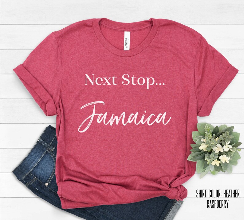 May include: Heather raspberry red t-shirt with the text "Next Stop... Jamaica" in white cursive font.